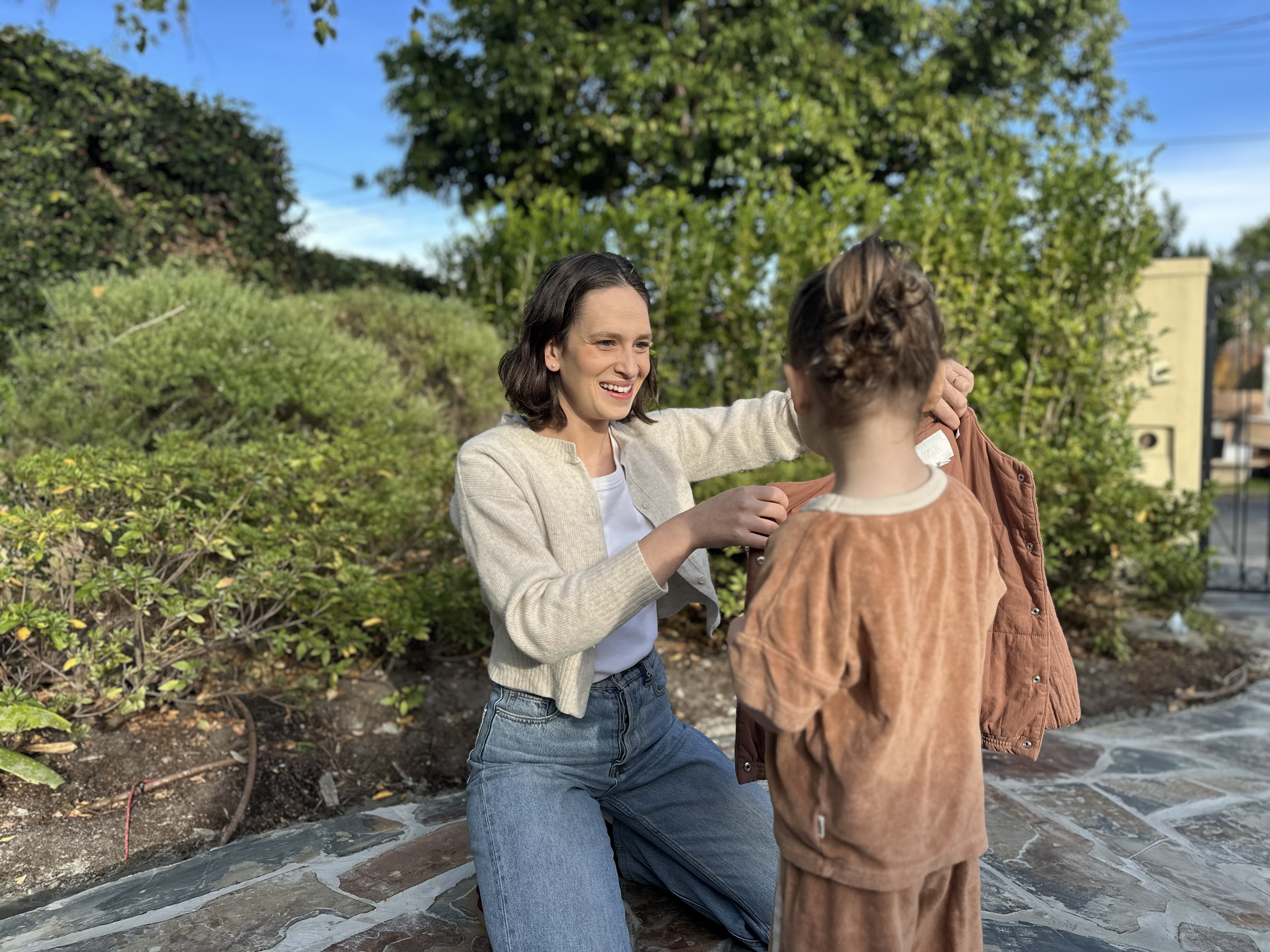 Child practising putting on a coat independently